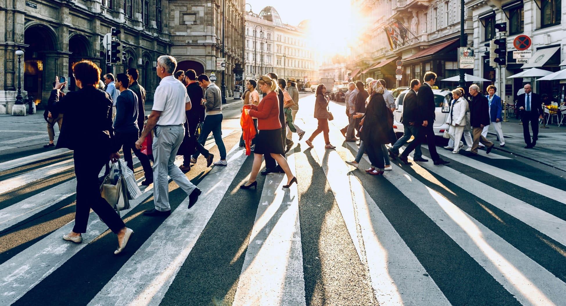 People walking across a zebra crossing in a city location