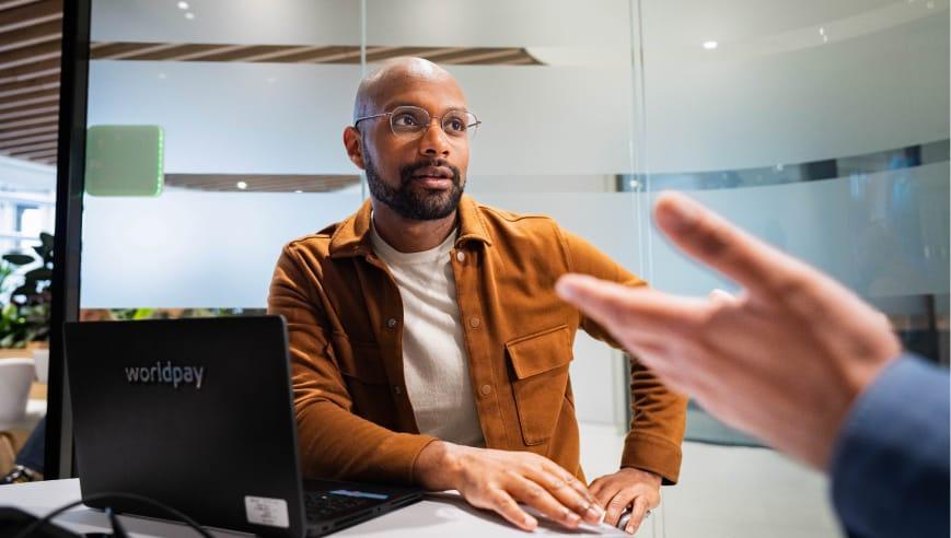 Man in orange shirt with computer