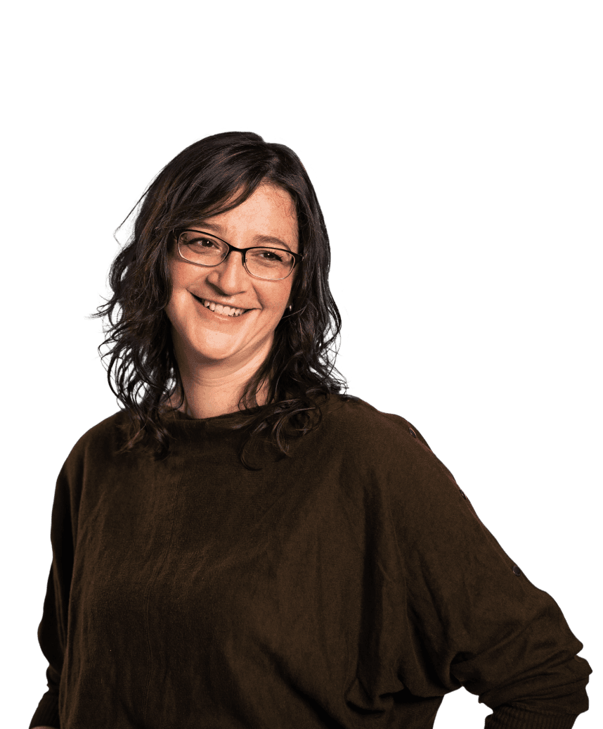 Headshot of a women smiling. She is wearing glasses and a brown top