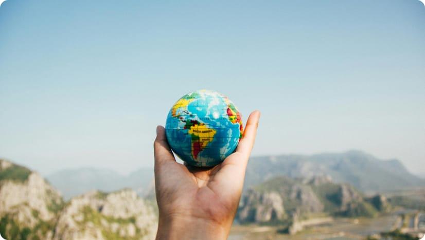 Person holding a globe.