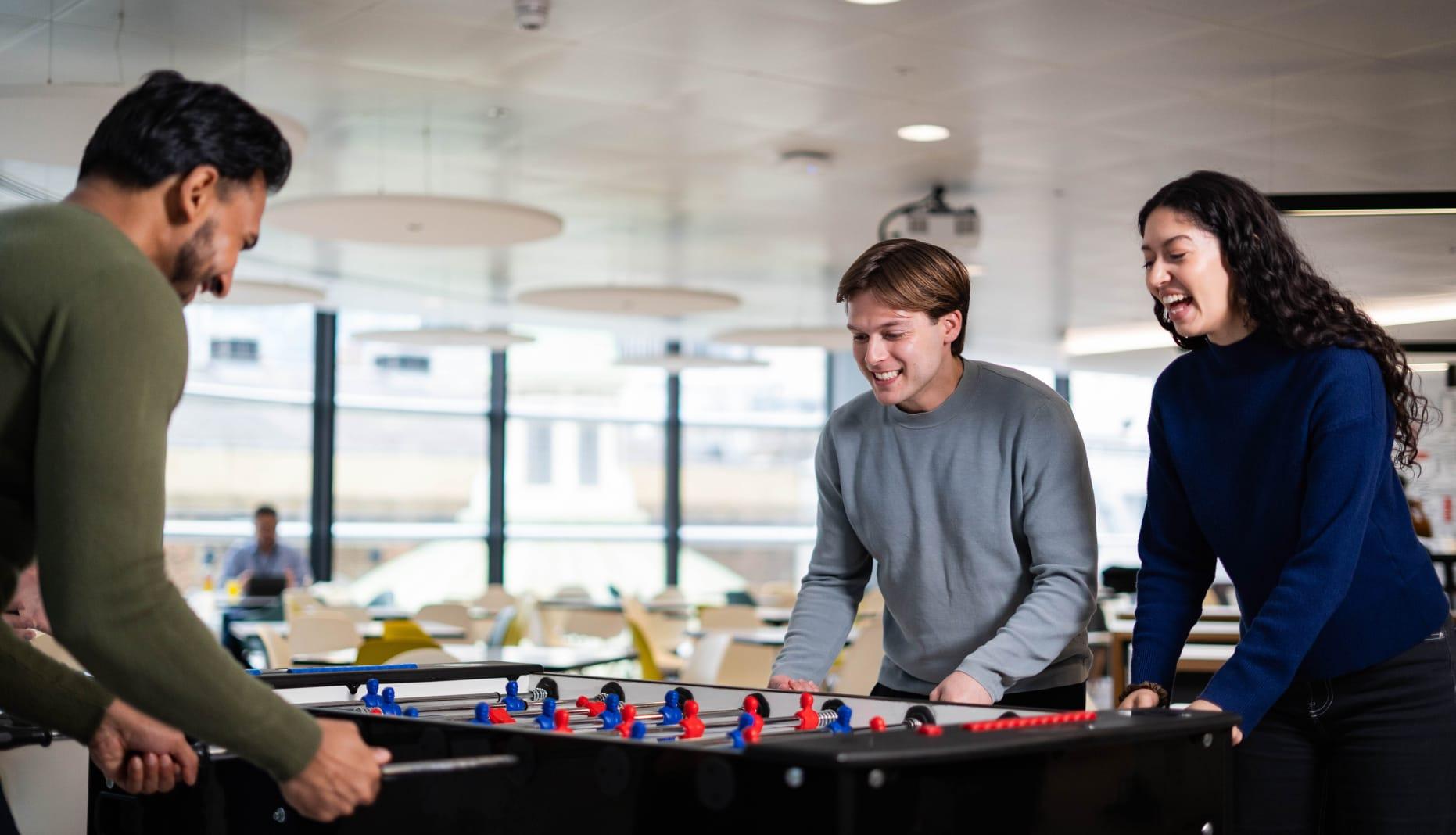 Team members playing table football.