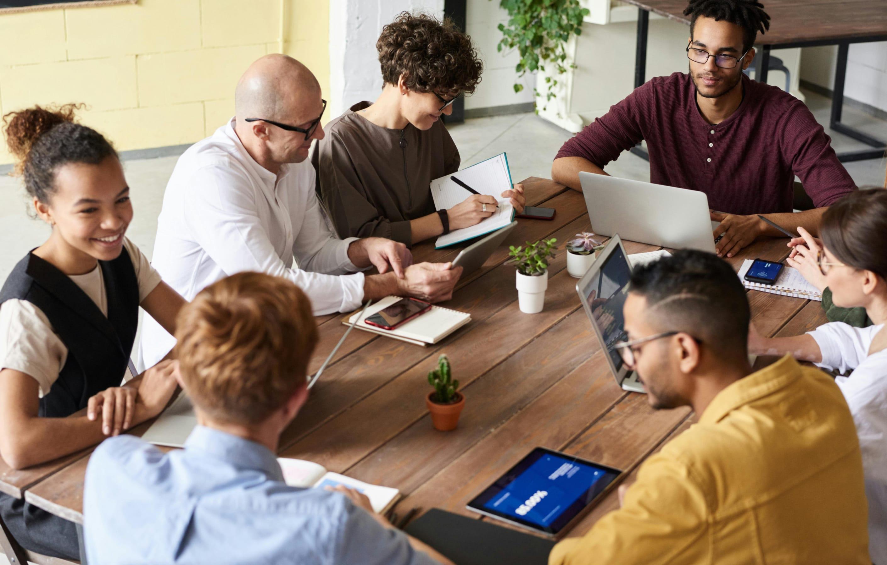 Group of diverse people in an office, sat around a table