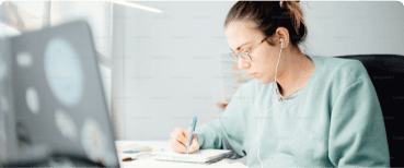 Women at a desk writing with a laptop