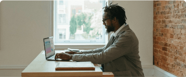 man at desk working with laptop